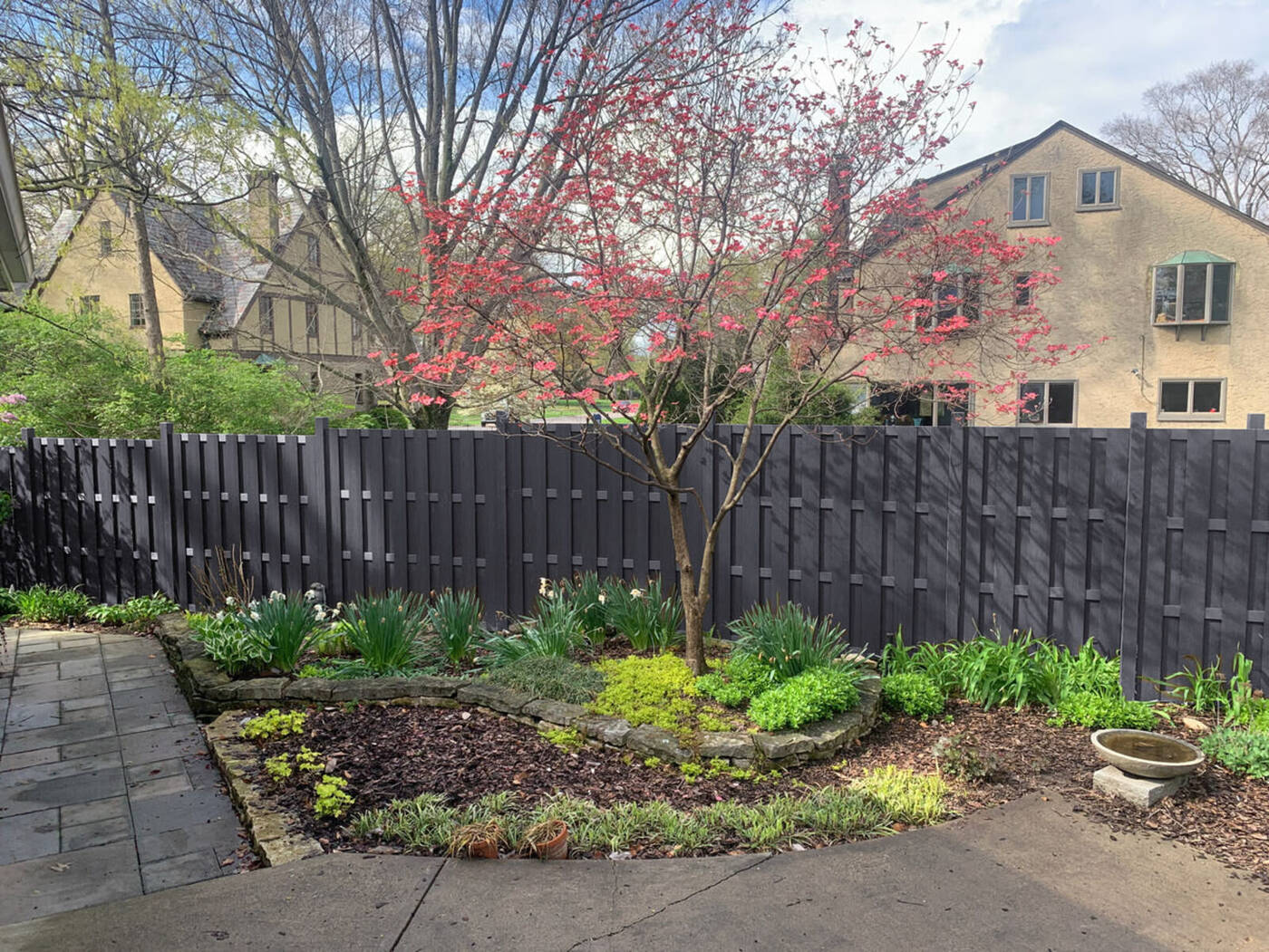 Frame It All shadowbox composite panel fence in Ironwood behind a garden bed